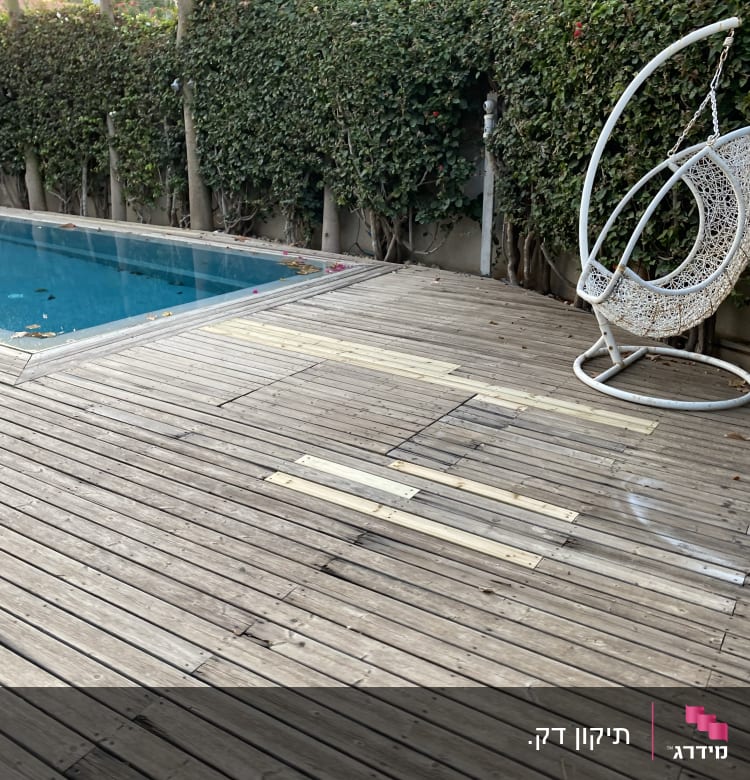 דק עץ עם תיקונים ליד בריכה